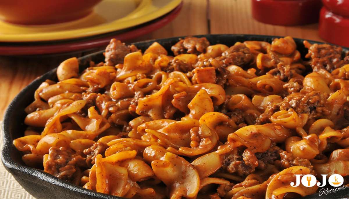 Baked hamburger hotdish with ground beef, pasta, tomato sauce, and melted cheese in a casserole dish — a comforting, family-friendly meal