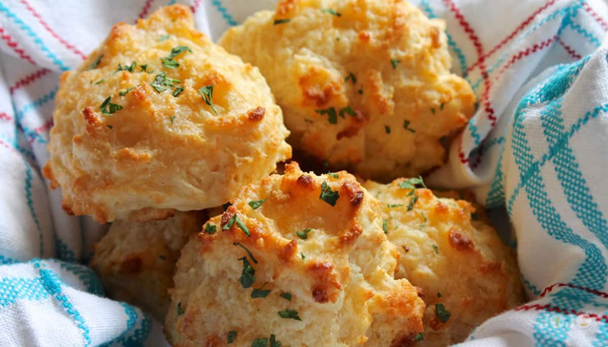 Homemade Red Lobster cheddar bay biscuits warm and buttery from the oven Golden cheddar bay biscuits topped with fresh parsley served in a cloth-lined basket