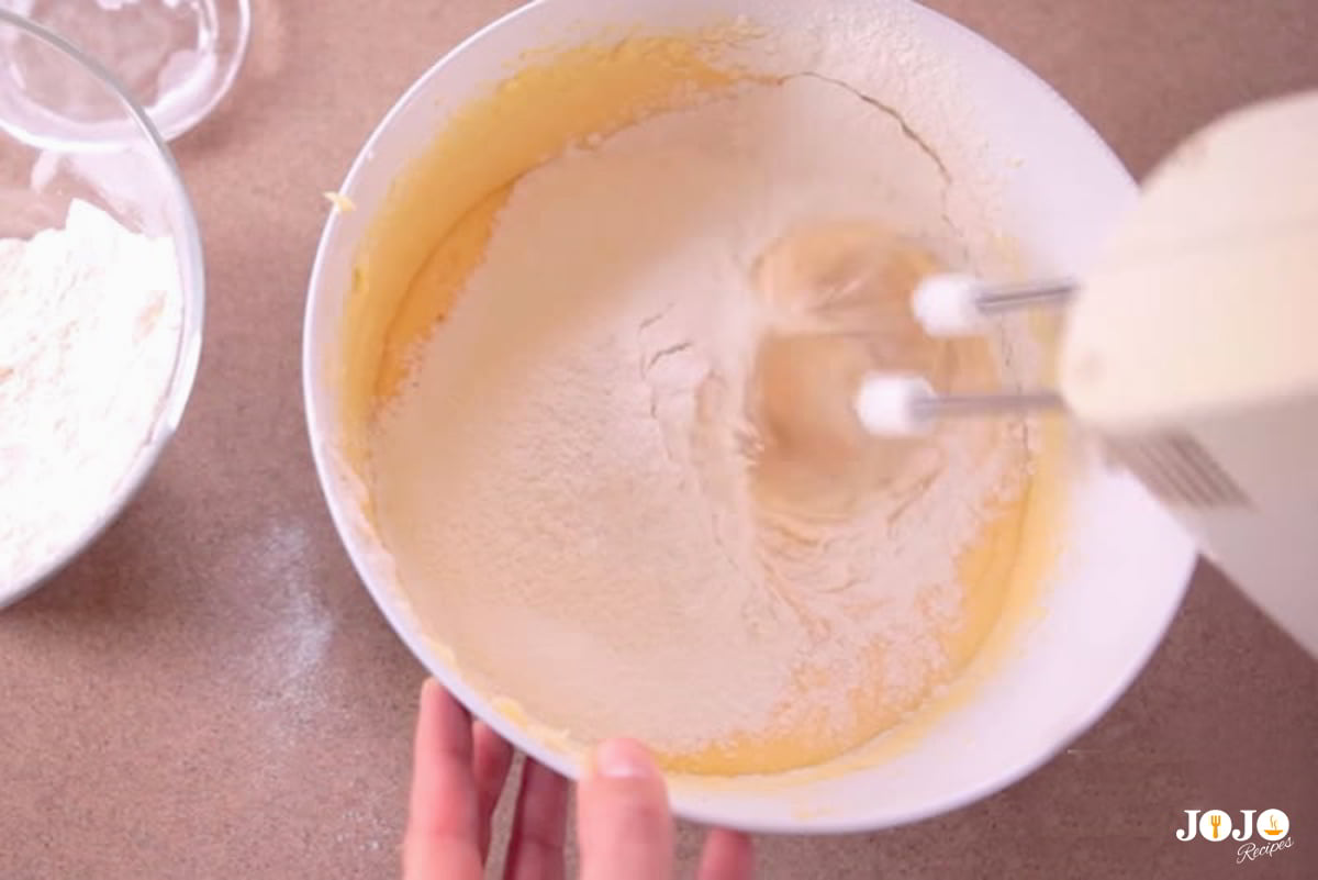 Step 2: Mix in the dry ingredients for applesauce cake Mixing dry ingredients into applesauce cake batter