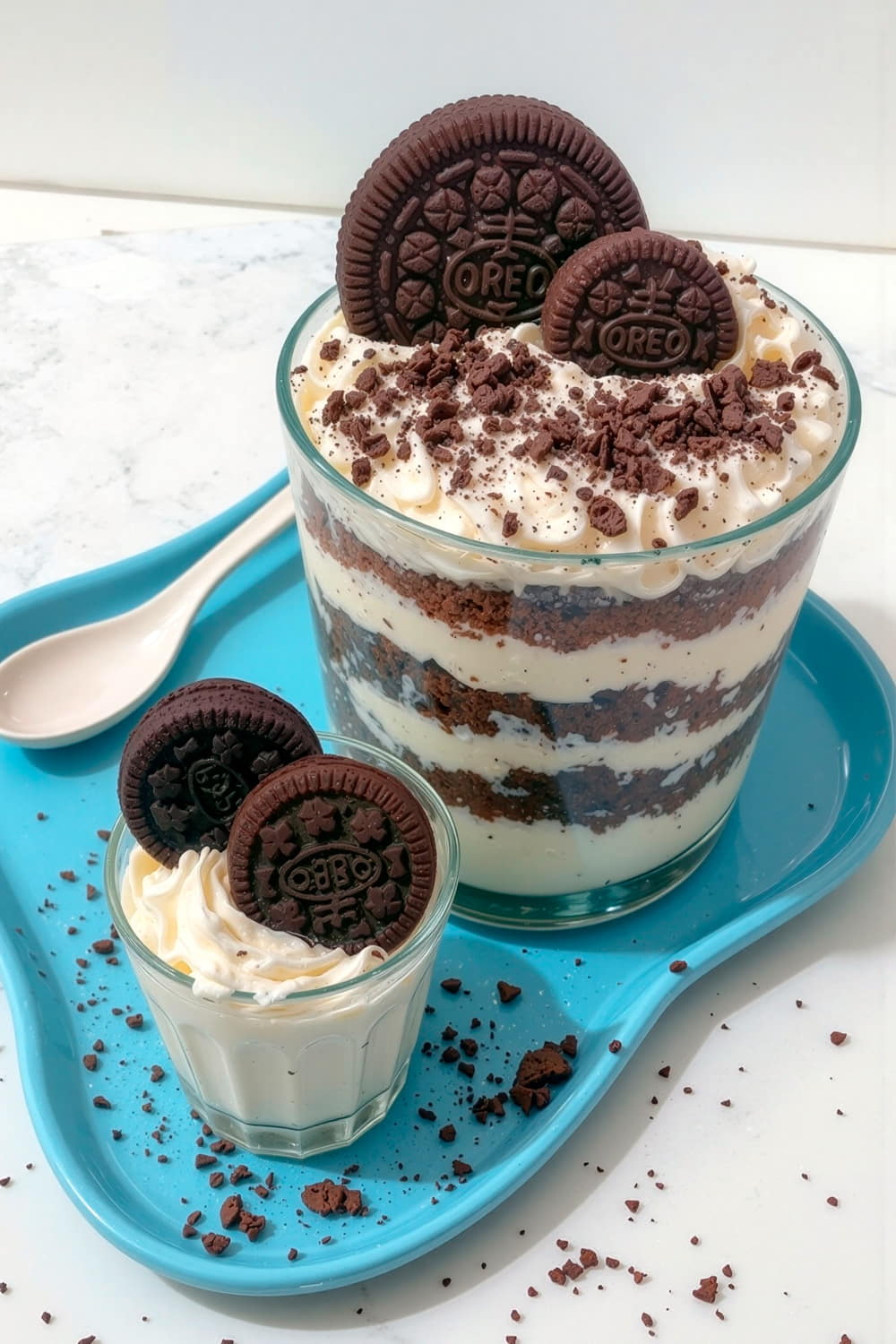 Easy dirt cake recipe in glass cups layered with creamy pudding, whipped topping, and crushed cookies
